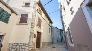 Eine enge Kopfsteinpflasterstraße, gesäumt von Gebäuden mit steinernen Fassaden und Holzläden.