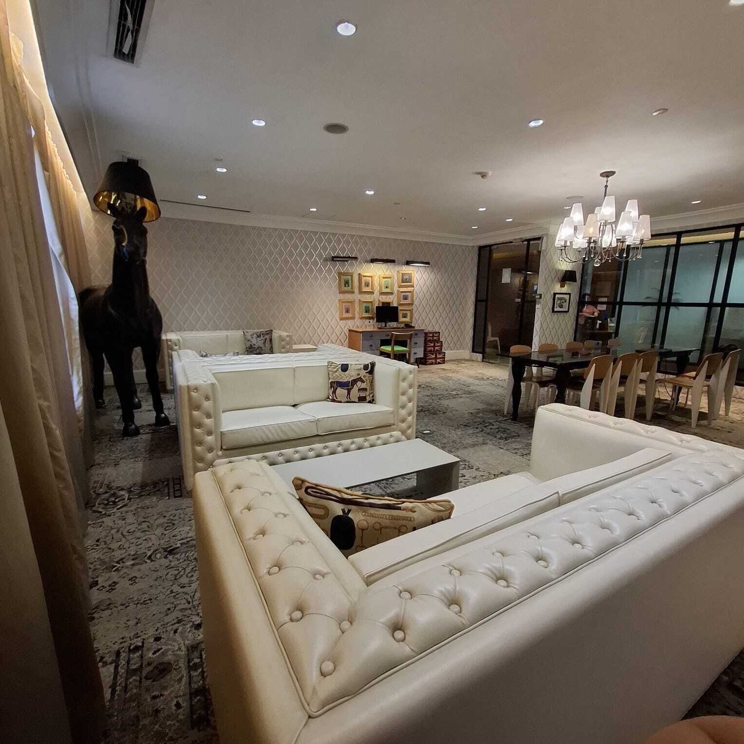 A modern living room with a sofa, a coffee table, and a chandelier.