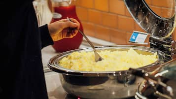 Een buffet met een grote metalen kom vol aardappelpuree.