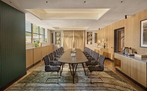 A conference room with a long table, chairs, and a wooden accent wall. - Hyatt Regency London Olympia (London)