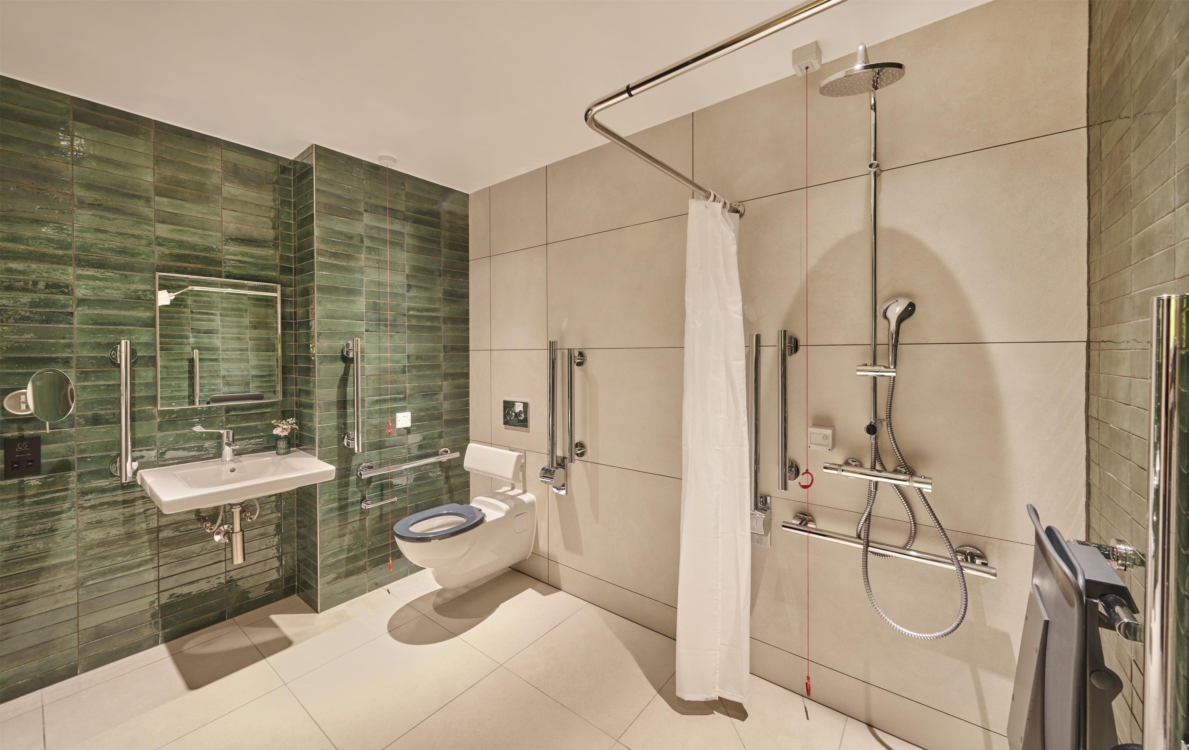 Ein modernes Badezimmer mit einer gläsernen Duschkabine, einer Toilette und einem Waschbecken.