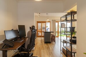 A modern office space with a desk, two monitors, a chair, and a shelving unit. - Casa Pet Friendly no Condom nio Bell Park (São José dos Campos)