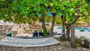 A hammock under a tree, a pool, stone walls, and outdoor furniture. - Gorgeous home in Postranje (Postranje)