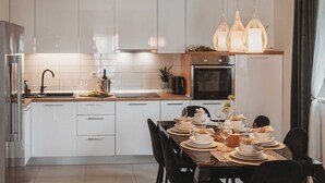 Een moderne keuken met witte kastjes, een houten aanrecht en een eethoek gedekt voor een maaltijd.