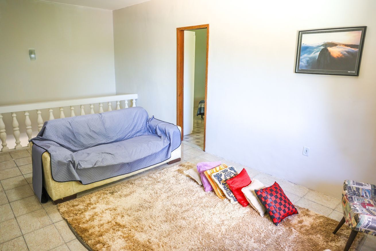 Una sala de estar con un sofá, una alfombra y un sillón.