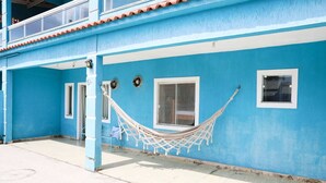 Ein blaues Gebäude mit einer Hängematte, einer Tür und einem Fenster.