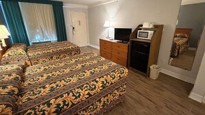 A hotel room with two beds, a TV, a microwave, a dresser, and a mirror. - Family-friendly Non-Smoking Double Bedroom in Southwest Houston with AC (Houston)