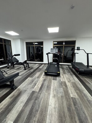 A gym with treadmills, weight machines, and a mirrored wall. - Cozy 1-bedroom apartment in lovely Panamá with AC, pool and gym (Panamá)