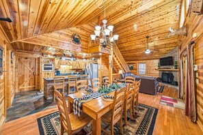 Ein Holzblockhaus-Innenraum mit Essbereich, Küche und Wohnbereich.