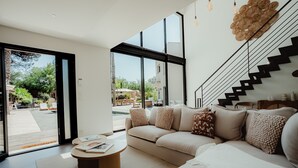 Un salon moderne avec un canapé, une table basse et un escalier.