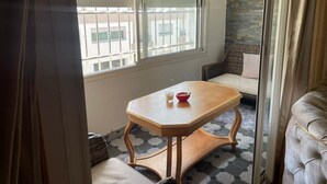 A small room with a wooden table, a red bowl, and a cushioned bench.