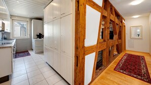 Une cuisine moderne avec des armoires blanches, une structure en poutres apparentes et un tapis rouge.