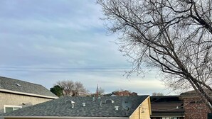 A single-story house with a red door, satellite dishes, and a paved driveway. - The Judge's Chambers: Superior King Bed (Prescott)