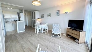A modern apartment with a kitchen, dining area, and living room. - Évasion Marine - Vue mer imprenable 180° (Quiberon)