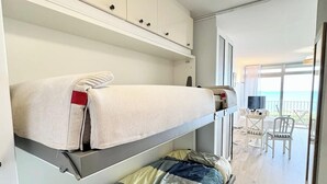 A modern room with bunk beds, a dining area, and a view of the sea. - Évasion Marine - Vue mer imprenable 180° (Quiberon)