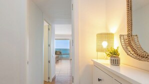 Ein Flur mit einer Lampe, einem Blumentopf und einem dekorativen Spiegel.