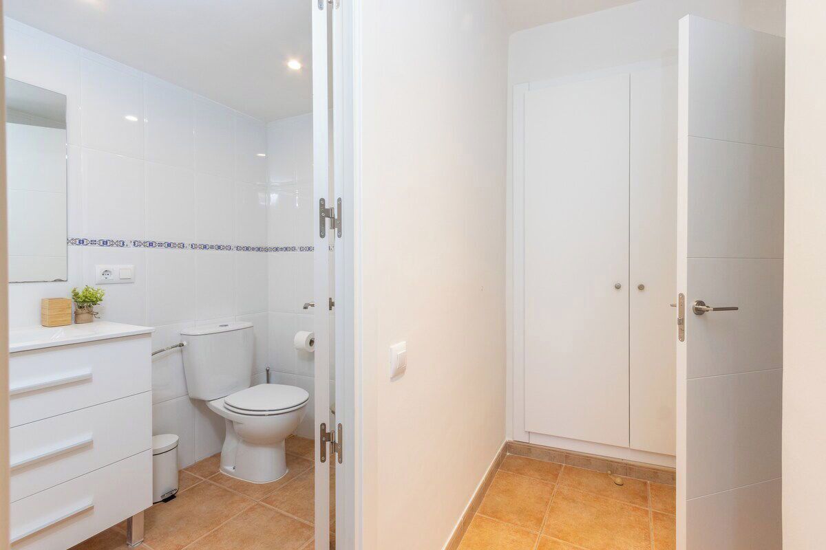 Un baño moderno con inodoro, lavamanos y mueble.