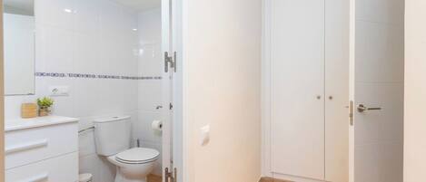 Un baño moderno con inodoro, lavamanos y mueble.