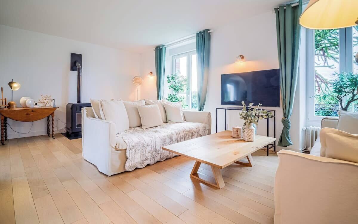 Ett vardagsrum med en soffa, ett soffbord i trä, en tv och en öppen spis.