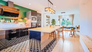 Una cocina moderna con una isla central, electrodomésticos integrados y un comedor con vistas.