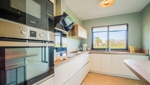 Una cucina moderna con elettrodomestici integrati, un'ampia finestra e vista sull'esterno.