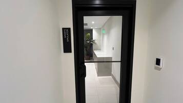 A hallway with a door labeled 'SPORTS SIMULATOR' and a TGI emergency exit sign.