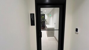 A hallway with a door labeled 'SPORTS SIMULATOR' and a TGI emergency exit sign.