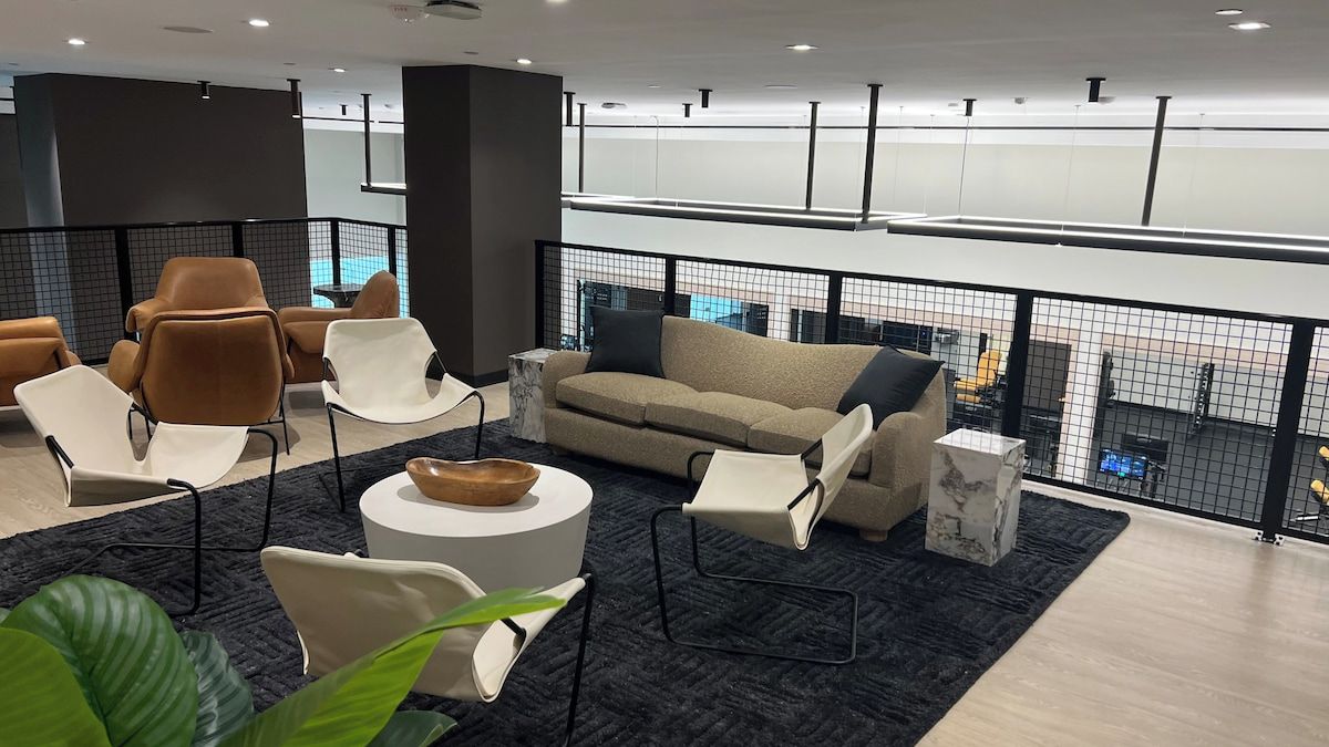 A modern lounge area with seating arrangements, a coffee table, and a view of the pool.