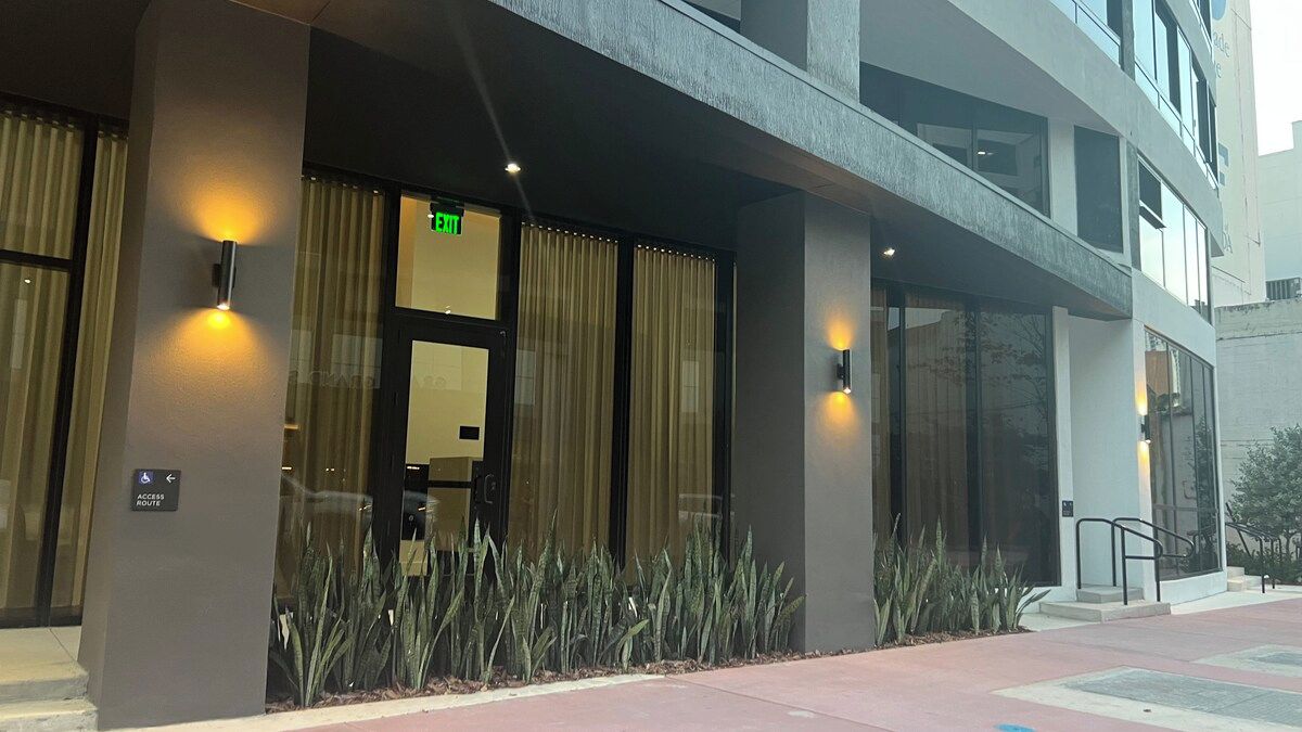 A hotel entrance with a glass door, a sign indicating an exit, and a wheelchair-accessible route.