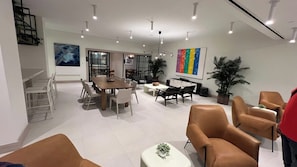 A modern interior with a dining area, seating, and a staircase.