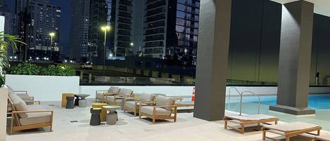 A rooftop lounge with outdoor seating and a pool.