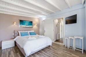 Ein Schlafzimmer mit einem Bett, Nachttischen, einem Fernseher und einem Bild an der Wand.