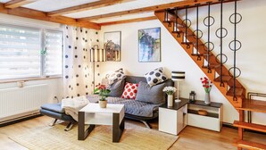 Un salon chaleureux avec un canapé, une table basse et un escalier doté de rampes circulaires.