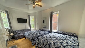 A bedroom with two beds, a ceiling fan, a TV, and a window with curtains. - GE, NEAR ZOO , Fairmount Park, Spacious 9 bedrooms 3 bathrooms entire house (Philadelphia)