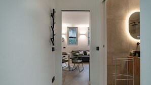 Un pasillo que conduce a una sala de estar con sofá, sillas y una mesa de comedor.