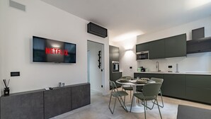 Una cocina moderna con comedor, televisor de pantalla plana y microondas integrado.