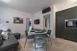 A modern living room with a dining area, a flat-screen TV, and a built-in oven. - 9 min. Walk from Porta Nuova, Design and Elegance (Milan)