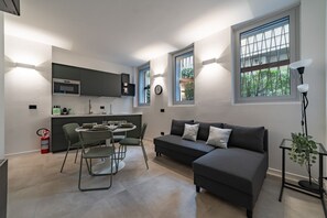 A modern kitchen with a dining area, a sofa, and a window with a view. - 9 min. Walk from Porta Nuova, Design and Elegance (Milan)