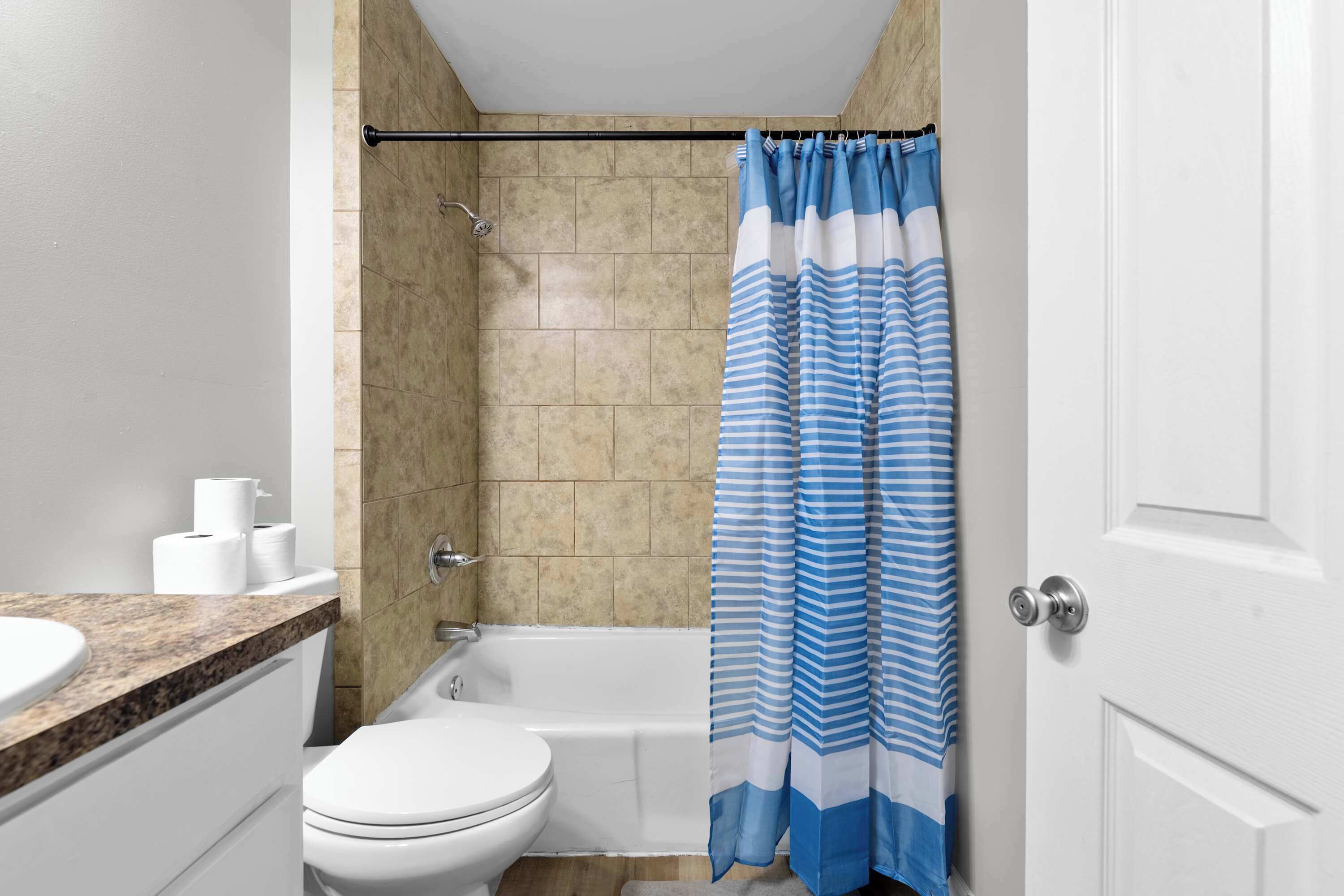 A bathroom with a toilet, sink, and bathtub.
