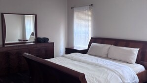A bedroom with a wooden bed, a dresser, a mirror, and a window with blinds. - 5bd Beautiful Modern house in Spring/The Woodlands (Spring)