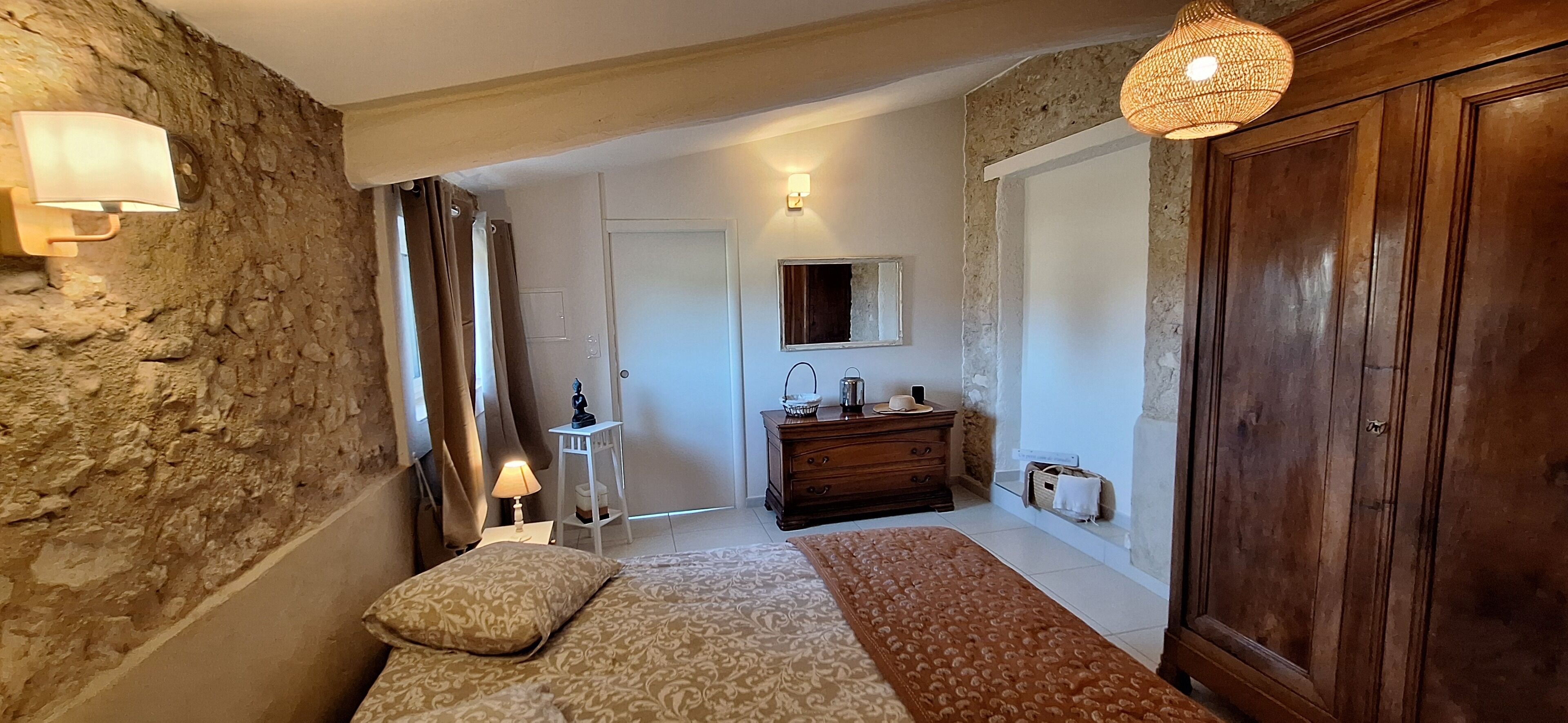 A bedroom with a bed, a dresser, a mirror, and a wardrobe.