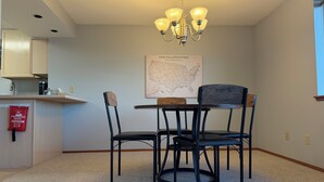 A dining area with a table and chairs, a map on the wall, and a fire blanket hanging on the wall. - Stunning water and mountain views, steps from Old Town Silverdale. (Silverdale)