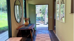 A hallway with a checkered floor, a wooden bench, a mirror, and a vase with dried flowers. - Epic views, modern luxury, private retreat in West Marin on hilltop 2 acre (Lagunitas-Forest Knolls)