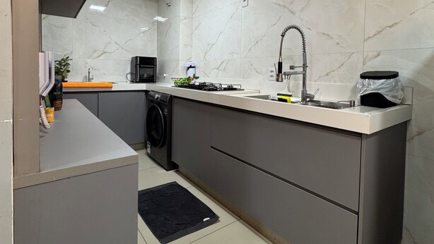 Een moderne keuken met een inbouwvaatwasser, een spoelbak en een kookplaat.