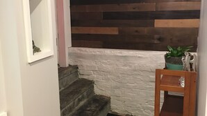 A staircase with a wooden wall and a white door. - Charming 1-bedroom apartment with AC in peaceful Nyack (Nyack)