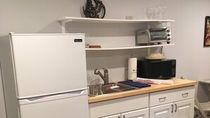 A kitchen with white cabinets, a white refrigerator, a microwave, and a toaster oven on a wooden countertop. - Charming 1-bedroom apartment with AC in peaceful Nyack (Nyack)