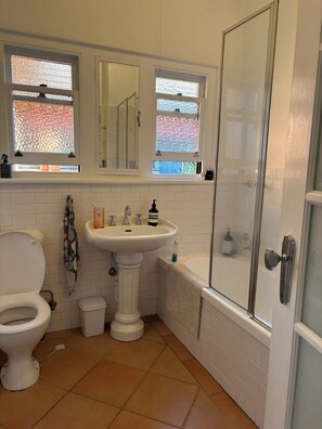 A bathroom with a toilet, sink, and shower. - Art deco apartment in St Kilda (St Kilda)