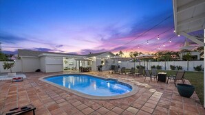 A backyard with a swimming pool, patio furniture, and a covered seating area. - Palm Blanc- Modern Retreat • Pool • Firepit (West Palm Beach)
