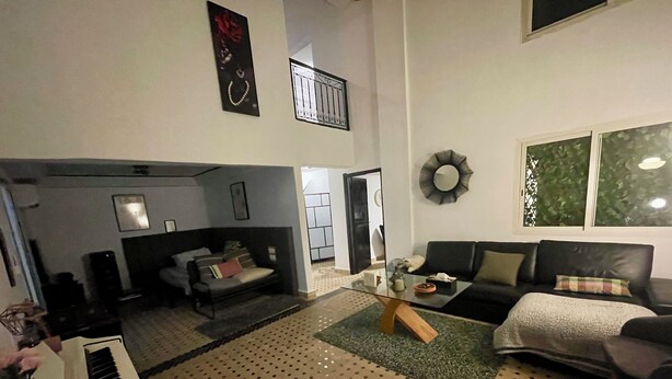 A living room with a sofa, a coffee table, a piano, and a patterned rug. - Au Riad des Sultans - Marrakech (Marrakech)