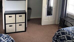 A room with a bed, a TV mounted on the wall, a wardrobe, and a mirror. - 2br Albany Corporate Comfort (Albany)